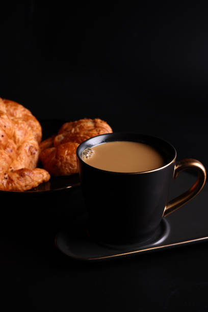 istock Hot latte coffee with Croissant coffee break isolated in black background 1820556607