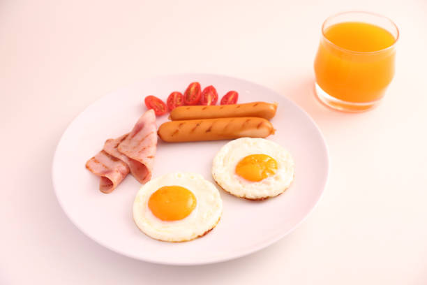 Fried eggs, chicken sausage, toasted bread with butter spread, cherry tomatoes and grilled mushrooms