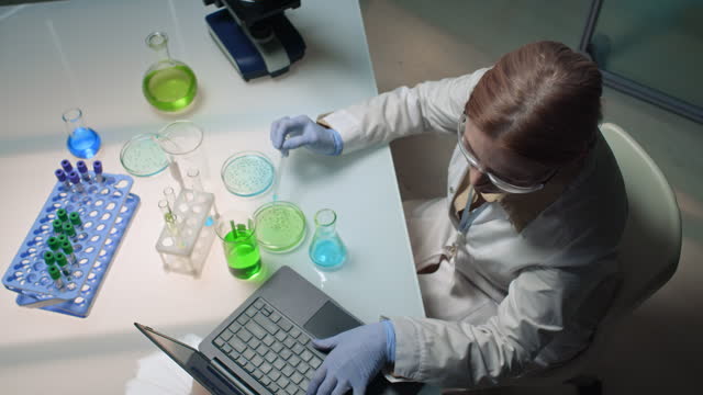 Female Researcher Dropping Liquid into Petri Dish