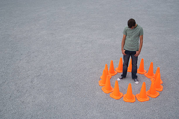 Man encircled by safety cones  trap stock pictures, royalty-free photos & images