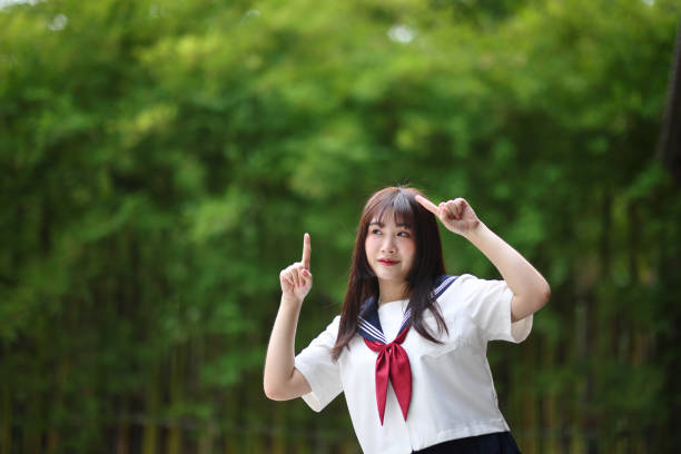 istock Japanese high school student with happy and pointing on copy space in bamboo background 1820563433