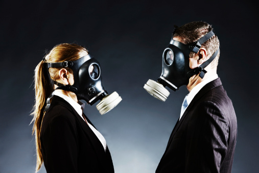 A formally-dressed couple wearing gas masks face each other. Could be a confrontation or a simple odor issue!