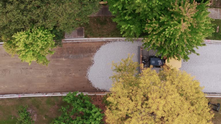 Aerial wide shot. road construction process in suburbs area. Top down shot