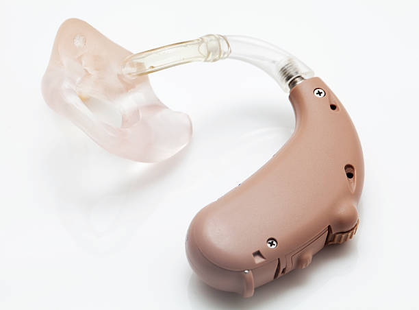 Digital Hearing Aid A digital hearing aid on a white backgroundImage of the hearing aid being worn: hearing aid photos stock pictures, royalty-free photos & images