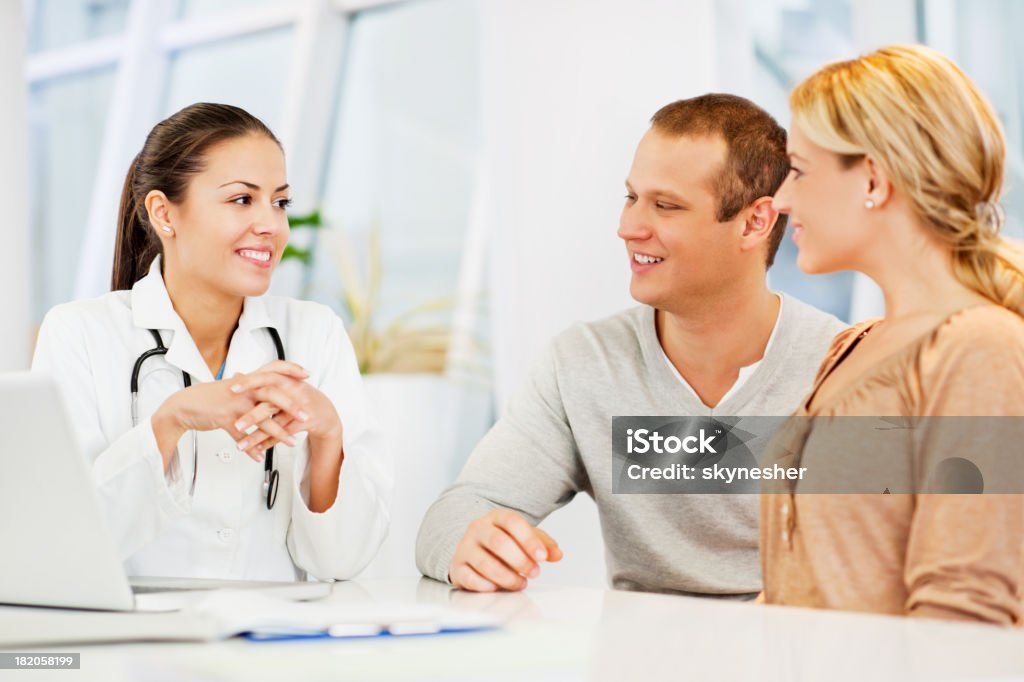 Doctora hablando con un par. - Foto de stock de Consultorio médico libre de derechos