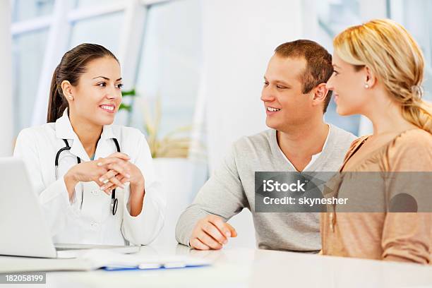 Doctora Hablando Con Un Par Foto de stock y más banco de imágenes de Consultorio médico - Consultorio médico, Parejas, Doctor