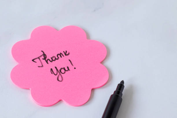 お礼の花の形をしたピンクの付箋紙に手書きのテキスト、白地に黒いマーカー