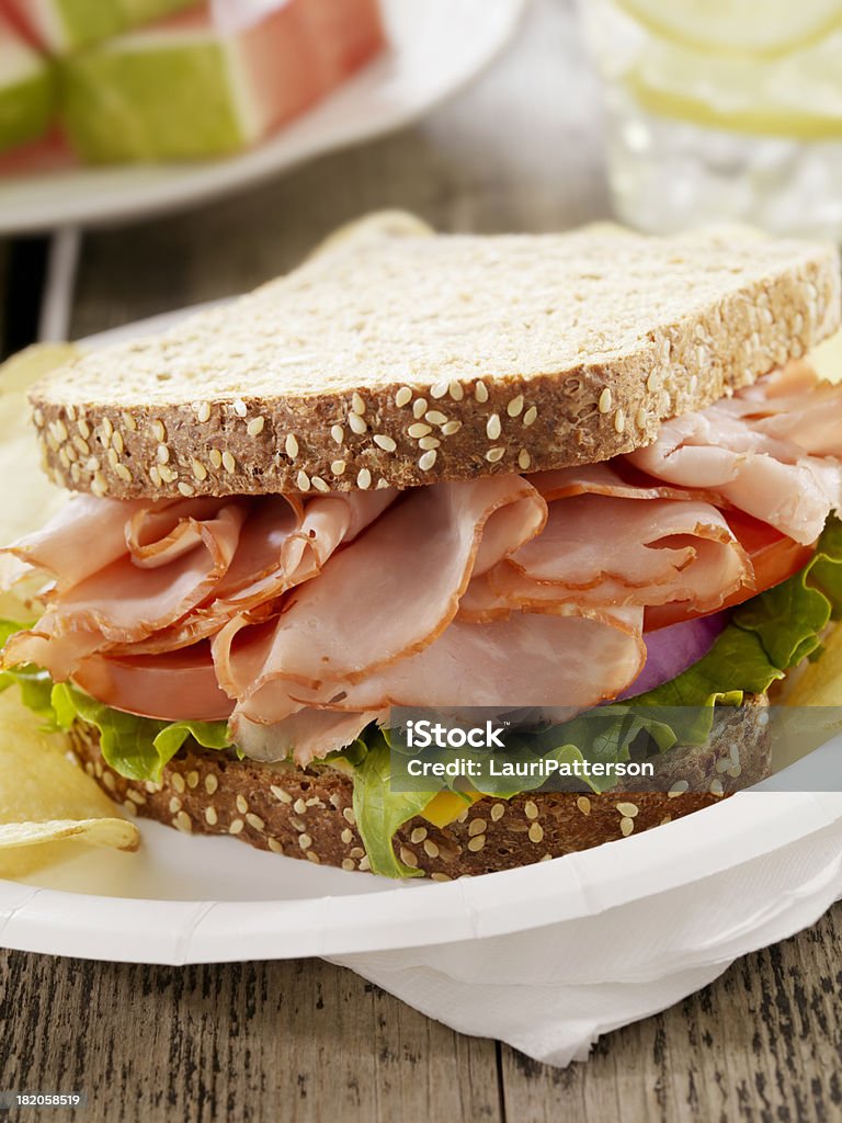 Ham and Cheese Sandwich at a Picnic "Ham and Cheese Sandwich with Lettuce, Tomatoes and Red Onion with Potato Chips -Photographed on Hasselblad H3D2-39mb Camera" Sandwich Stock Photo