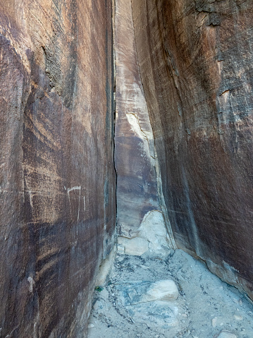 Narrow dead end slot canyon with  ancient rock art on the wall.