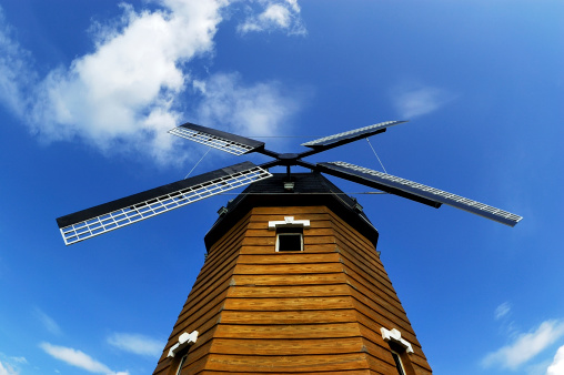 a wooden windmill in the sunshine.