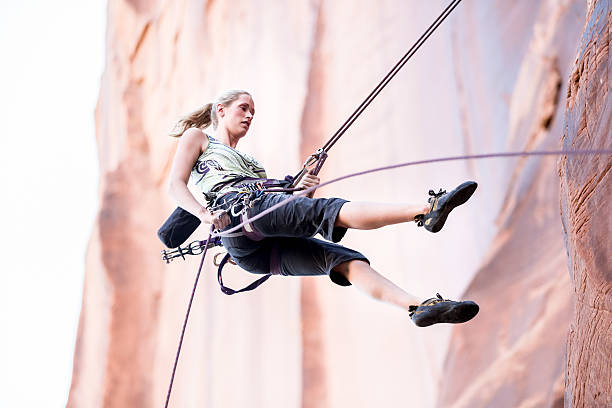 escaladeur jeune femme sur une falaise de grès - rock climbing mountain climbing women achievement photos et images de collection