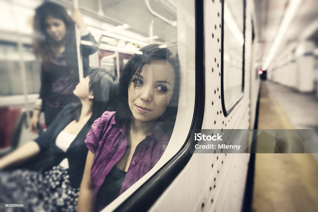 Day Dreaming Woman in the Subway "Pensive young woman looking out of the window of subway train, thinking and day dreaming, while to girls in the background chatting with each other. Reflection of subway train window, selective focus, subway ambient light. Toronto Subway Station, Canada." Toronto Stock Photo