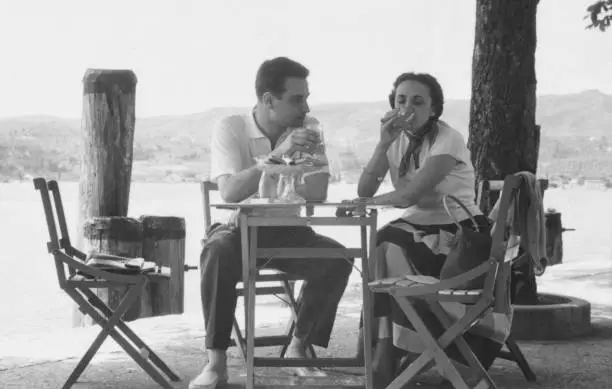 Young couple sitting on a sidewalk cafe. 1952.