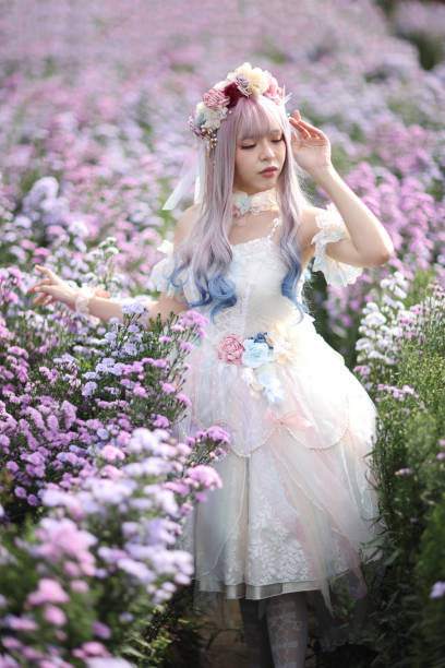 hermosa mujer joven con vestido blanco de lolita con jardín de flores de moda japonesa - maquillaje para cosplay de anime fotografías e imágenes de stock