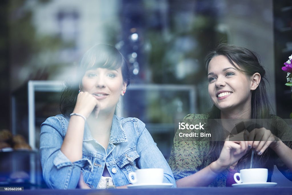 Duas jovens mulheres sentado no café, sorridente, vista através de vidro - Royalty-free Berlim Foto de stock