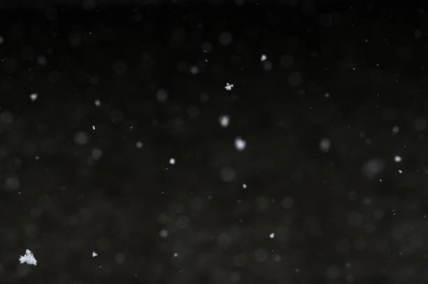 istock Bokeh of white snow on a black background. Snowfall - design element. 1820607526