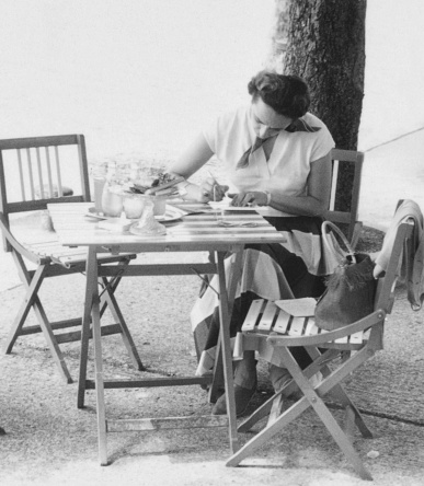 Young woman sitting on a sidewalk cafe. 1952.