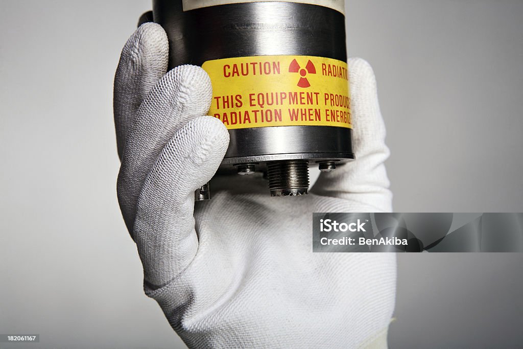 Mano che tiene una parte di attrezzatura radioattivo - Foto stock royalty-free di Arrugginito