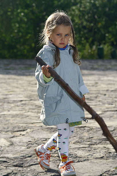 istock Sad little girl with a stick 182061399