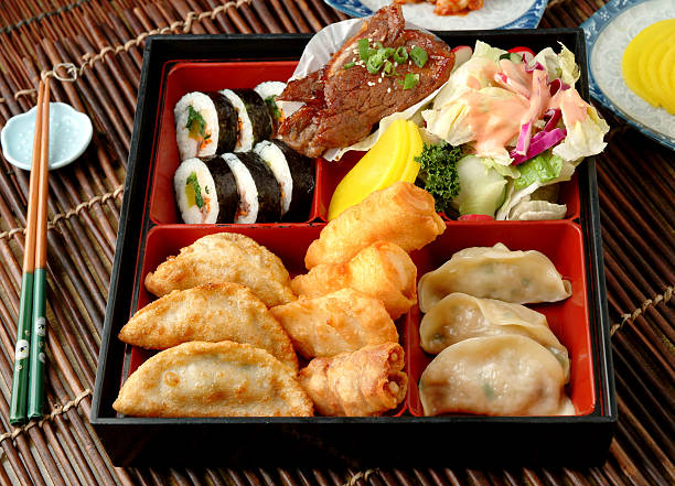 Lunch Box Korean Combination Bento (Lunch Box) with Korean BBQ short Rib, Tempura, Kimbab & Dumplings empty bento box stock pictures, royalty-free photos & images