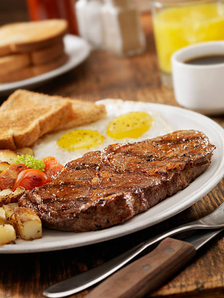 Steak and Eggs "Grilled Rib Eye Steak with Sunny-side up Eggs, Hash Browns, Grilled Tomatoes and Toast -Photographed on Hasselblad H3D2-39mb Camera" steak and eggs breakfast stock pictures, royalty-free photos & images