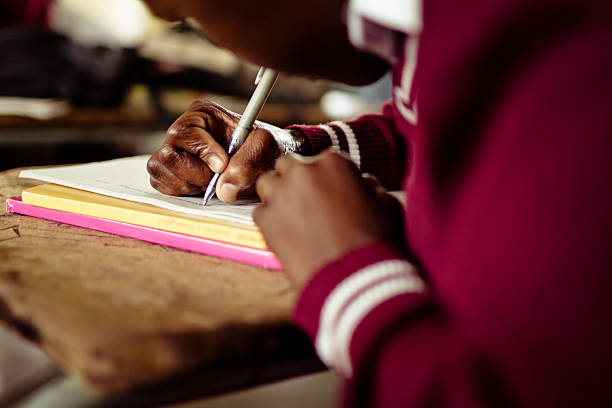 Closeup image of South African girl writing at her desk stock photo