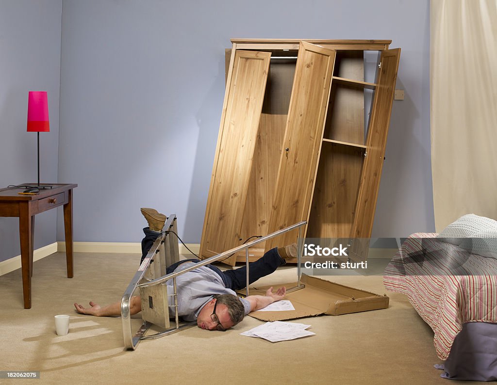 diy disaster man makes a mess of his self assembly wardrobe then falls off his ladder DIY Stock Photo