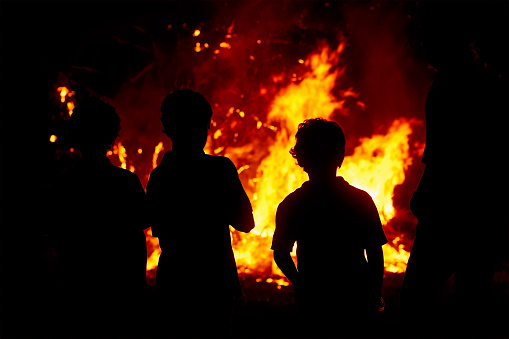 Standing around the bonfire at night.