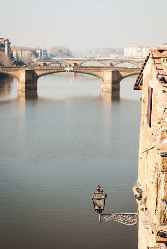 The Arno river in Florence viewed from Vasari Corridor. A classical street lamp in the foreground.
