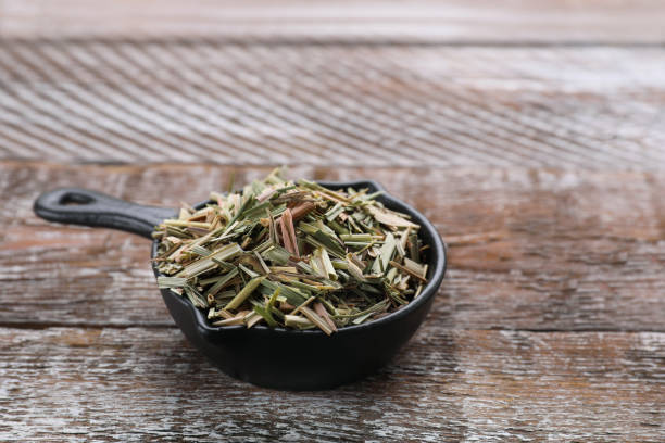 istock Small saucepan with aromatic dried lemongrass on wooden table. Space for text 1820650960