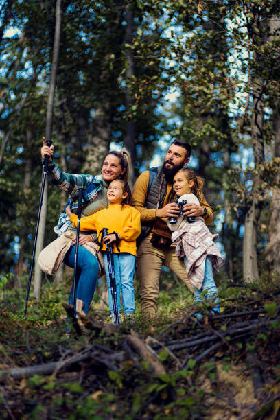 istock Smiling family of four exploring nature while hiking in forest. 1820656264