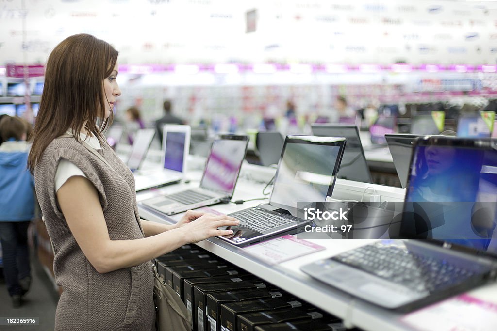 Kobieta wybiera laptopa - Zbiór zdjęć royalty-free (Sklep)