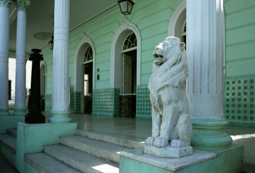 Entrance of the old Cuban office building with statue of the Lion on the steps