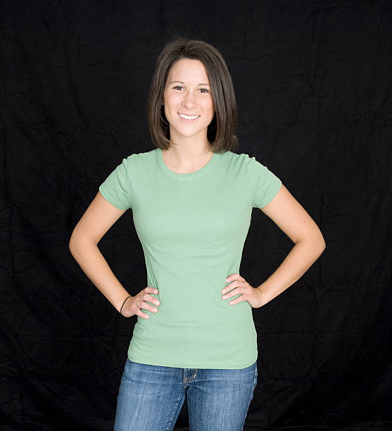 A young woman smiles in front of wall. 