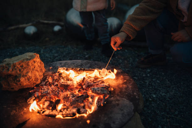 istock Man roasting marshmallow by the fire outdoors. 1820680993