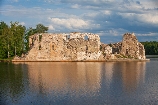 Aerial view of Koknese medieval castle ruins on the bank of Daugava river. Koknese Castle dating from the 13th century. The castle was situated on a high bluff overlooking the Daugava river valley. In 1965 a hydroelectric dam was built downriver, creating a reservoir That partially submerged flooded the castle and the surrounding valley.