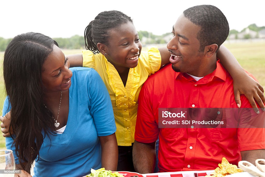 Córka z rąk wokół jej rodziców na Stół piknikowy - Zbiór zdjęć royalty-free (Afroamerykanin)