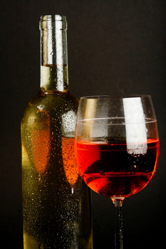 A bottle of white wine and a glass of red wine.