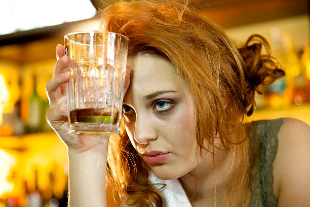 Too much to drink Young woman with a hangover holding her almost empty cocktail glass hangover stock pictures, royalty-free photos & images