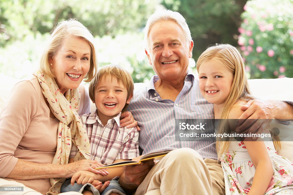 Retrato de avós com netos no sofá leitura - Royalty-free Avô Foto de stock