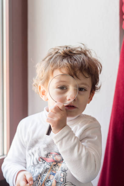 istock Child next to a curtain looking with a magnifying glass 1820689699