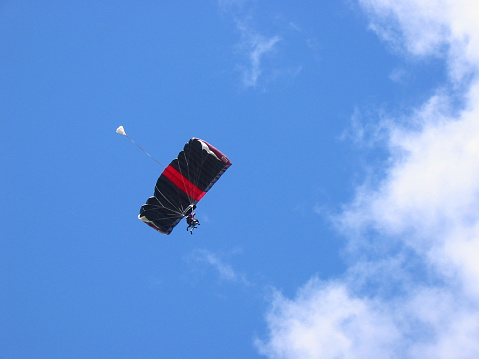 tandem skydivers floating towards clouds.