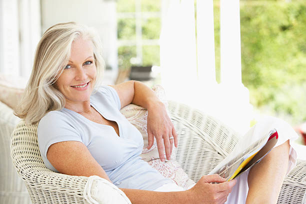 istock Senior Woman Sitting Outside Reading Magazine 182070102