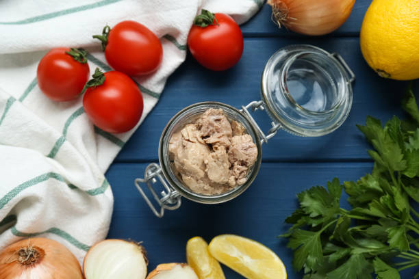 istock Flat lay composition with tasty cod liver and different products on blue wooden table 1820707420