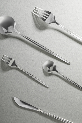 Forks, knife and spoons on grey background, flat lay. Stylish cutlery set