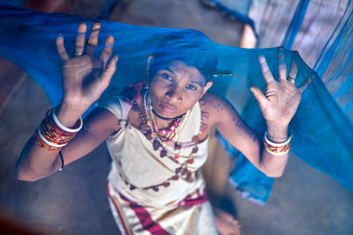 A girl from the Indian region of Odisha in her bed with the mosquito net that protects her from malaria