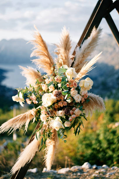 Colorful bouquet on the stand of a wedding triangular arch standing in the mountains