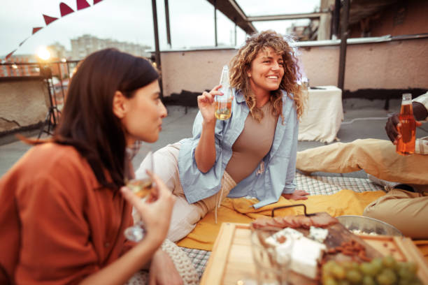 istock Two female friends having fun during rooftop party 1820718855