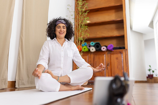 Happy yoga instructor doing an online class