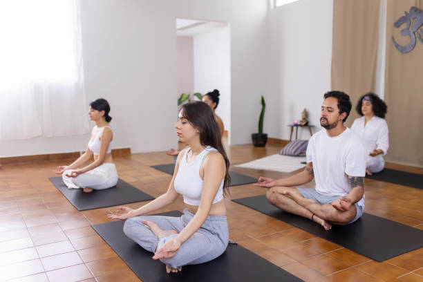 istock Yoga group sitting on half lotus meditating 1820728762